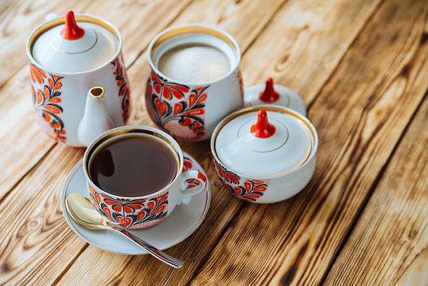 istock Tea cups with teapot on wooden table 529683984