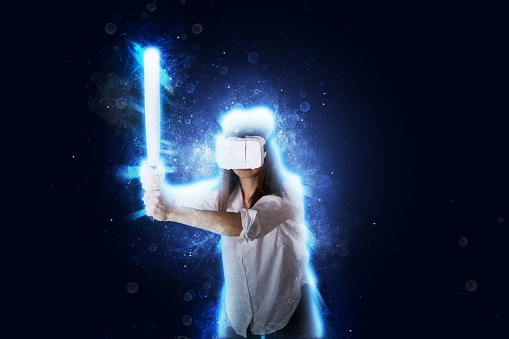 Woman is exploring her virtual reality simulator world. Young woman wears a virtual reality headset. She is holding a bat, preparing to hit someone.