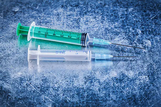 Photo of Medical single-use needle syringes on metallic background medici