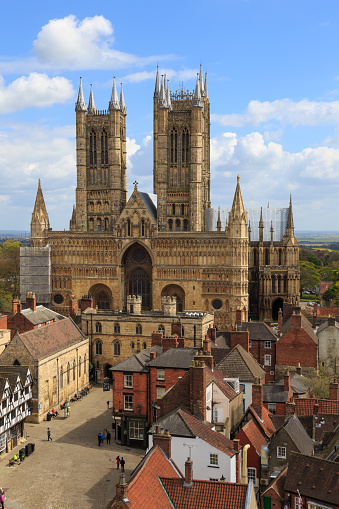 Lincoln, England - May 3, 2016: Front of Lincoln Cathedral. Castle Hill visible in foreground. Viewed from the walls of Lincoln Castle.