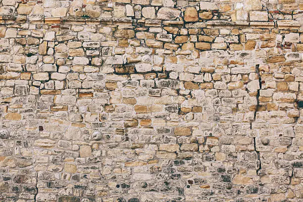 Old stone wall texture. Fortified stone wall of an ancient fortress from the Roman Empire.