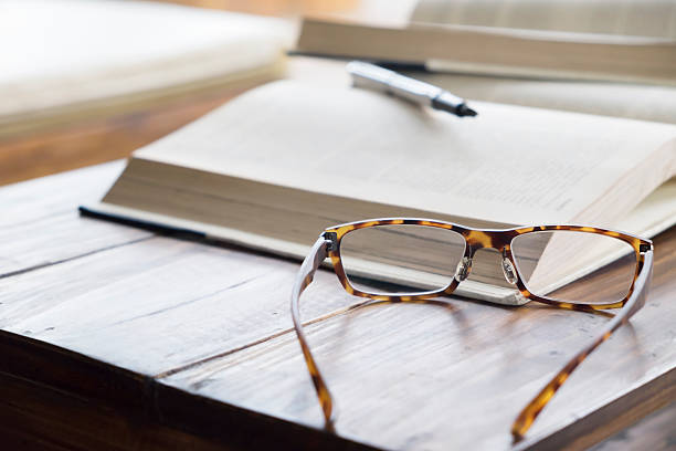 lunettes vintage sur ouvrir un livre dans la bibliothèque ou de café. - book book cover healthcare and medicine medical exam photos et images de collection