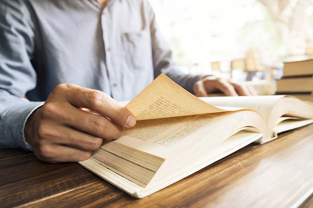 homme lisant un livre dans la bibliothèque ou de café. - book book cover healthcare and medicine medical exam photos et images de collection