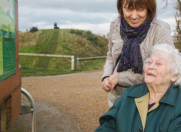 счастливый образ, как пожилые женщины разделяет время с ее отпуск по уходу за ребенком - senior women senior adult bench flower стоковые фото и изображения