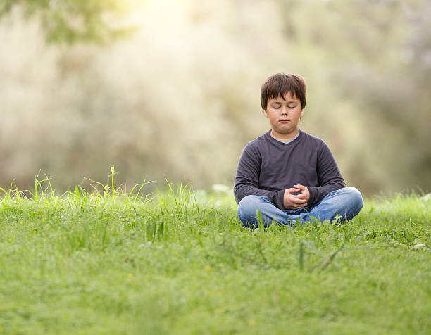 istock young boy meditating zen like in  nature 529690435
