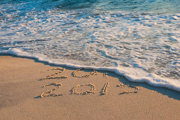 istock New Years, 2014-15 drawn in sand washing away by waves 529691847