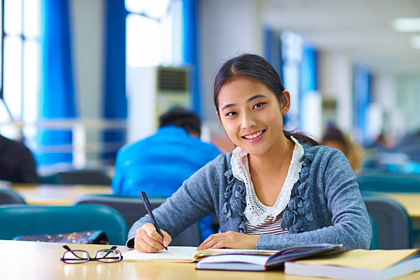 istock pretty young asian college student study in the library 529691913