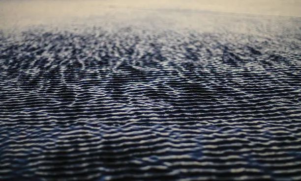 The flow of the ocean creates texture on the sand.