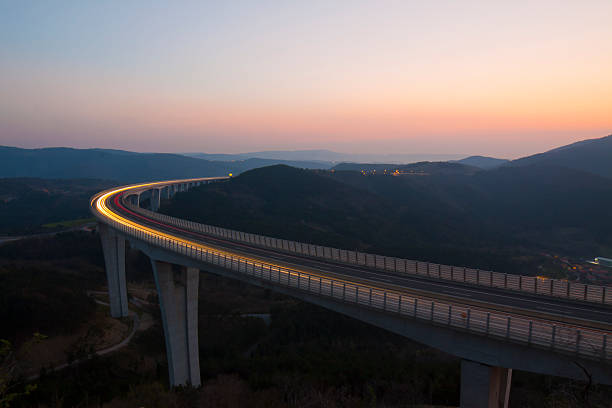 viaducto de la autopista al atardecer - asphalt high angle view street traffic fotografías e imágenes de stock