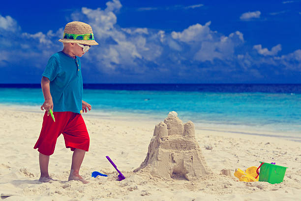 istock little boy building sand castle on beach 529722519
