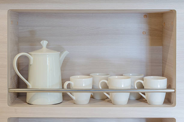 istock teapot and cups on wooden shelf 529745719
