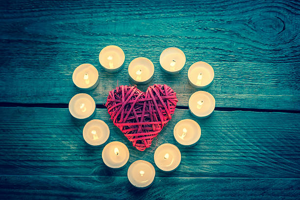 istock Heart with burning candles on the wooden background 529747155