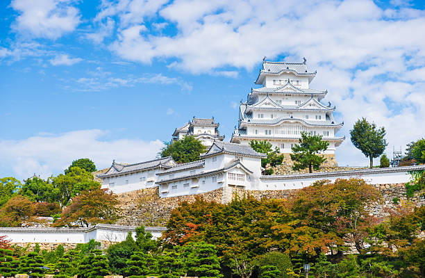 Himeji, Japan - October 24th, 2014: Autumn had arrived to Himeji-jo Castle. Himeji Castle is a hilltop Japanese castle complex located in Himeji, in Hyōgo Prefecture, Japan. The castle is regarded as the finest surviving example of prototypical Japanese castle architecture, comprising a network of 83 buildings with advanced defensive systems from the feudal period.
