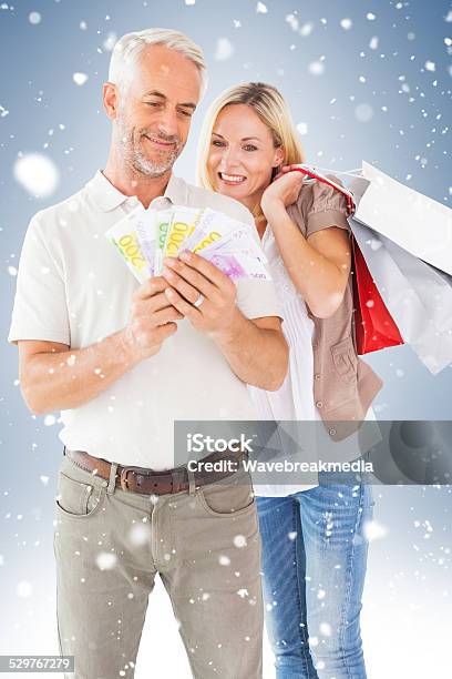 Happy Couple With Shopping Bags And Cash Stock Photo - Download Image Now - 30-39 Years, 35-39 Years, 50-54 Years