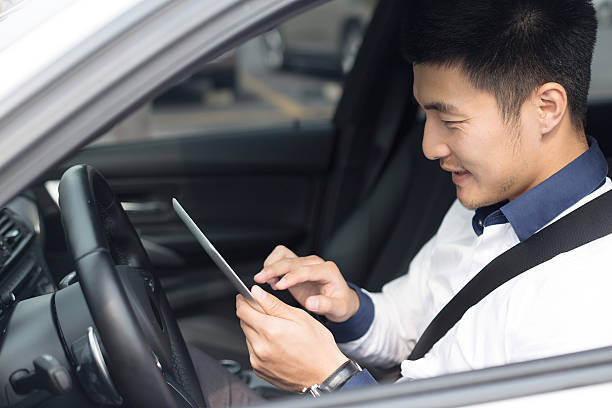 istock asian young businessman using smart tablet in car 529771553
