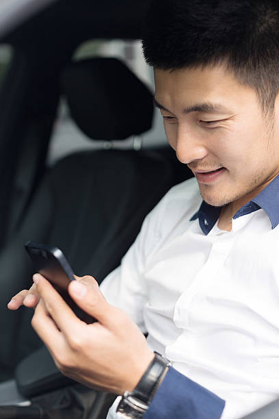 istock asian young businessman using smartphone in car 529771561