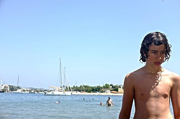 istock Young teen boy standing on the beach 529773709