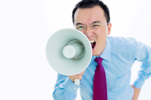 Businessman shouting through the megaphone.