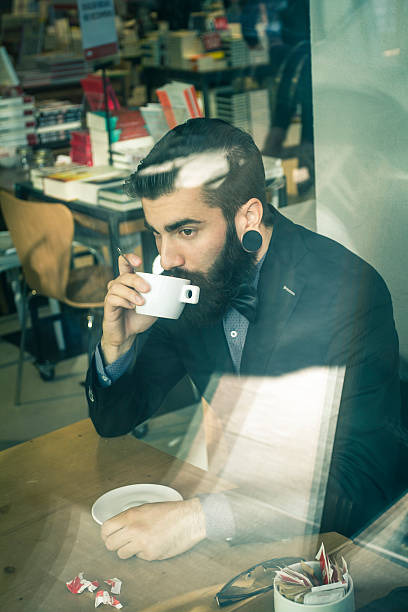 istock Stylish Hipster in a book-cafe with coffee or cappuccino 529784805