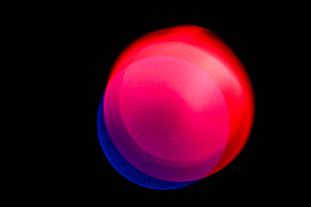 Superpositioned Defocused Light Combining Red and Blue Blue and red defocused point sources of light are superpositioned on top of on another to create a large, multi-colored round glob.  Black background.  This abstract orb appears to transform as a result of the mixing colors of light.  morph transition stock pictures, royalty-free photos & images