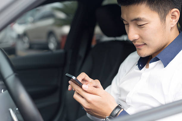 istock asian young businessman using smartphone in car 529790691