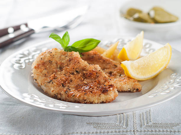 Chicken or pork schnitzel Chicken or pork schnitzel with lemon wedges, selective focus scaloppini stock pictures, royalty-free photos & images