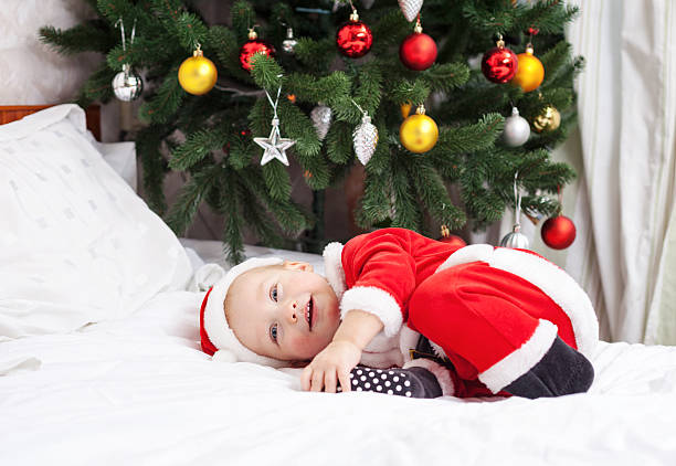 istock Baby boy in Santa costume lying on bed 529803645