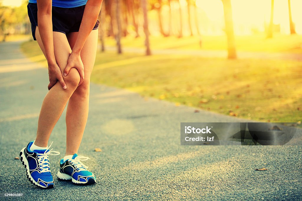 sports  injury Runner athlete leg  got a pain while jogging at tropical park trail, Adult Stock Photo