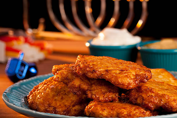 latkes davanti a una menorah - latke foto e immagini stock