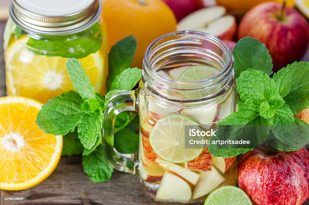 Mug delicious refreshing drink of apple fruits with mint Mug delicious refreshing drink of apple fruits with mint on wooden, infused water Close-up Stock Photo