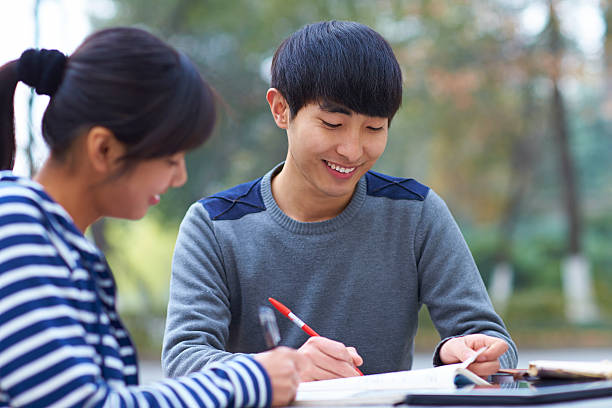 istock two asian college students study together outdoor in the campus 529834231
