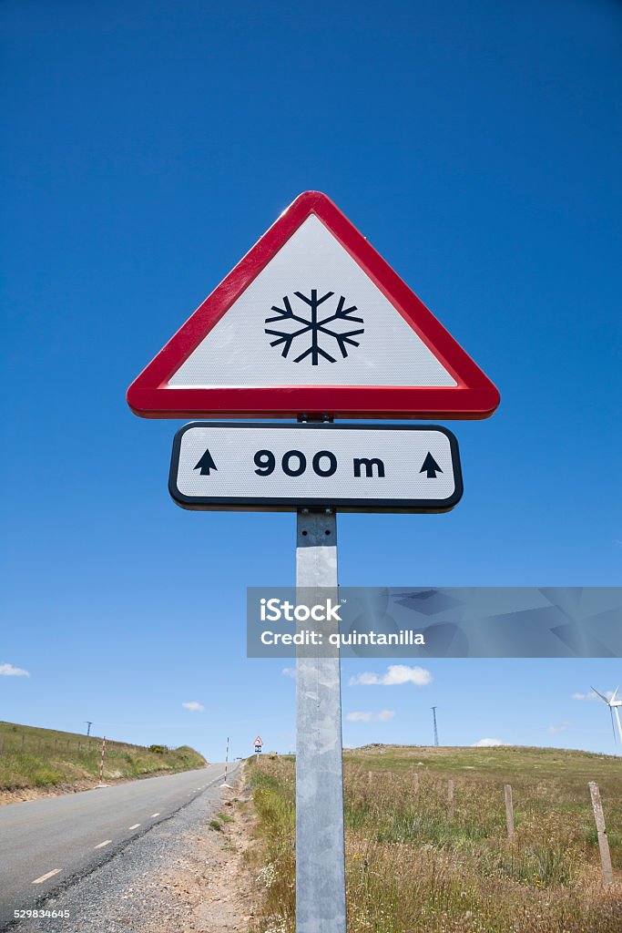 snow dangerous road signal metal pole with traffic signal advice danger snow at 900 metres in rural road next to Madrid Spain Europe Advice Stock Photo