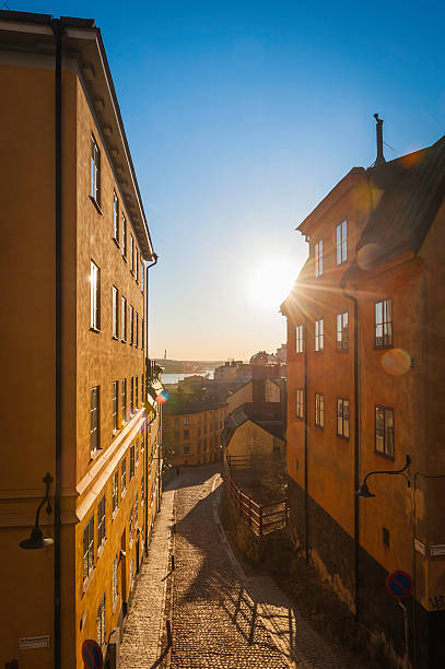 Stockholm sunrise sunlight flaring over cobbled streets of Sodermalm Sweden Bright early morning sunlight flaring over the stucco villas and cobblestone streets of Sodermalm overlooking the harbour of Stockholm, Sweden's vibrant capital city. ProPhoto RGB profile for maximum color fidelity and gamut. sodermalm photos stock pictures, royalty-free photos & images