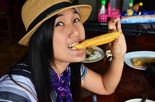 istock Thai woman eating Rice porridge  with deep-fried doughstick 529835855