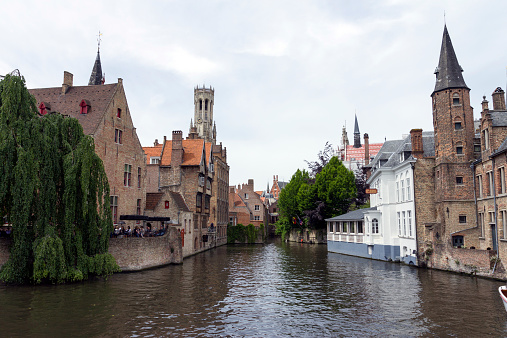 Bruges, Belgium - June 14, 2013: Canal in Bruges with the Belfort tower in the background.