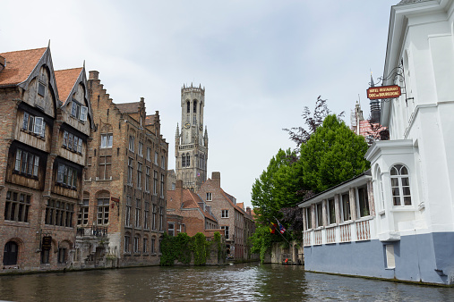 Bruges, Belgium - June 14, 2013: Canal in Bruges with the Belfort tower in the background.