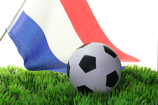 Flag of Netherlands with a football in a field