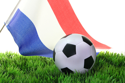 Flag of Netherlands with a football in a field