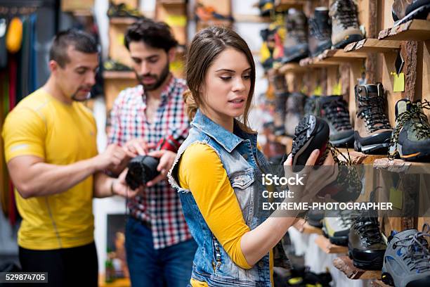 Woman In The Store Looking At Hiking Boot Stock Photo - Download Image Now - Chain Store, Fashion, Adult