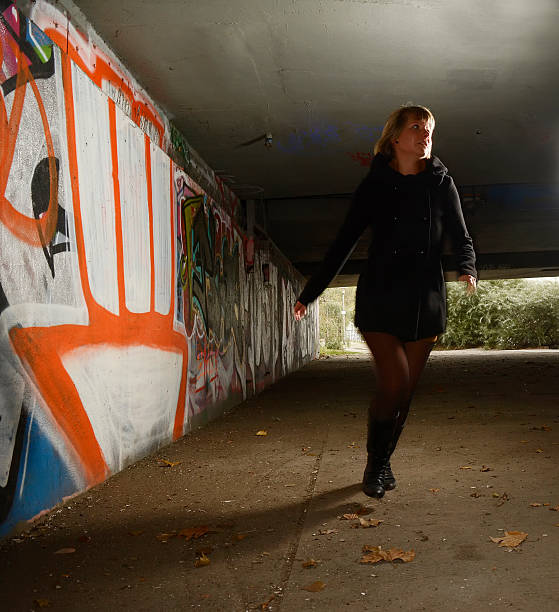 istock Frightened young woman alone in tunnel, running away 529875549