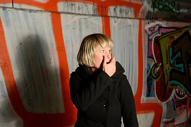 istock Frightend young woman alone in tunnel, hand on mouth 529875563