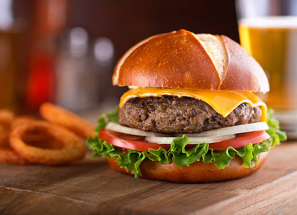 gourmet-cheeseburger breze brötchen - beer hamburger american culture beef stock-fotos und bilder
