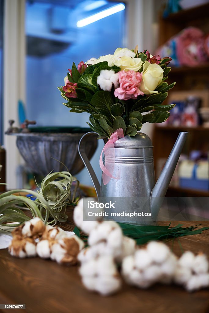Elegant flower arrangement Lovely flower bouquet in decorative watering can on counter in flower store Art And Craft Stock Photo