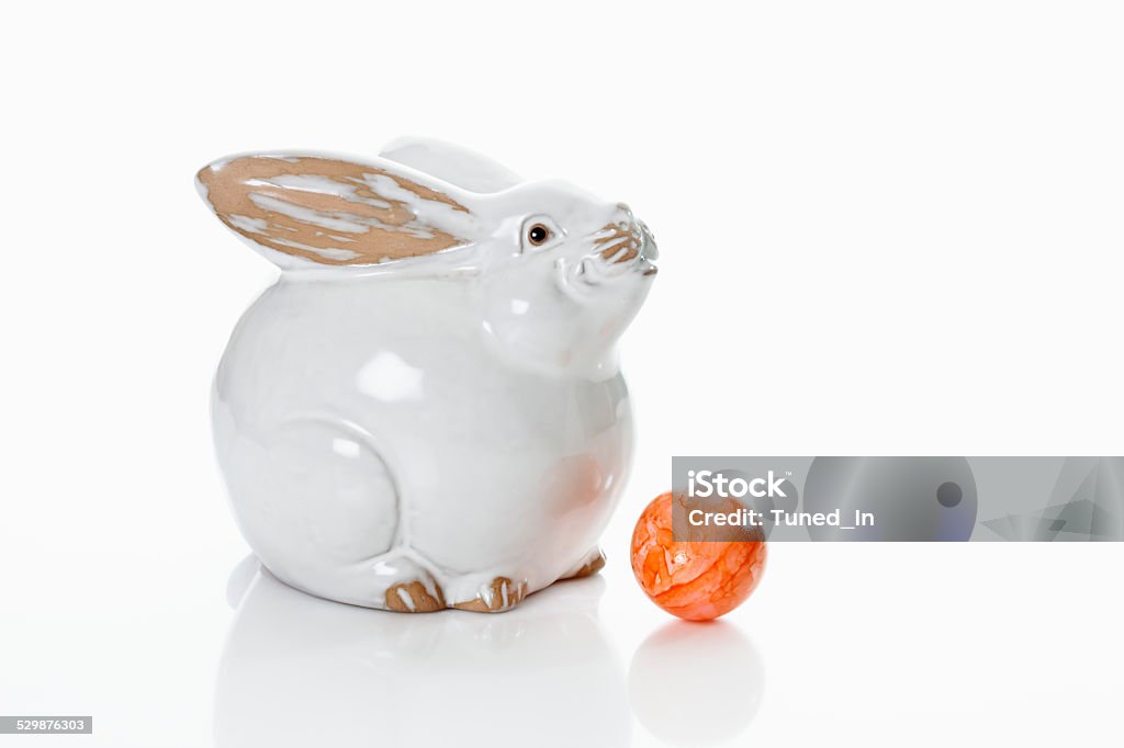 Porcelain Easter bunny on white background with dyed Easter egg Celebration Stock Photo