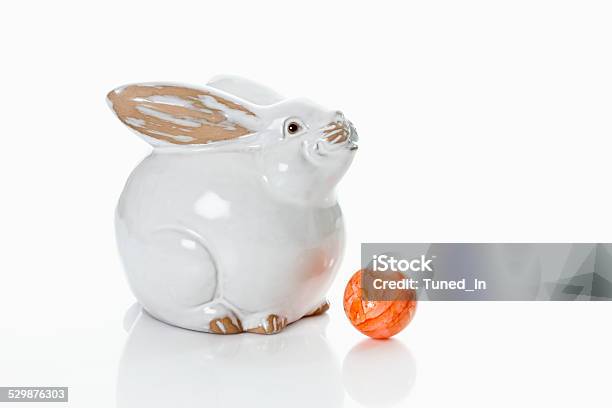 Porcelain Easter Bunny On White Background With Dyed Easter Egg Stock Photo - Download Image Now