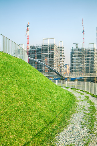 Walking path with green grass and construction site 