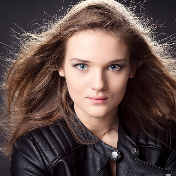 young woman portrait with beautiful Long Hair Blowing In Wind isolated on gray 