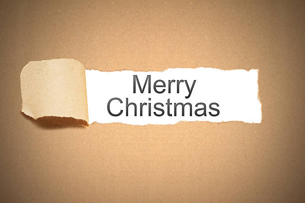 istock brown paper torn to reveal merry christmas 529915265
