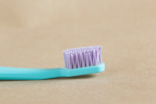 Old toothbrush on a brown paper background.