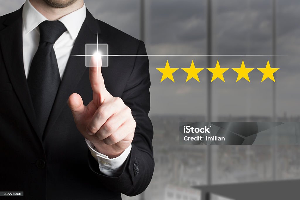 businessman pushing button five star rating businessman in black suit pushing button five star rating Homepage Stock Photo